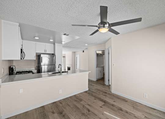 A kitchen with a fan on the ceiling.