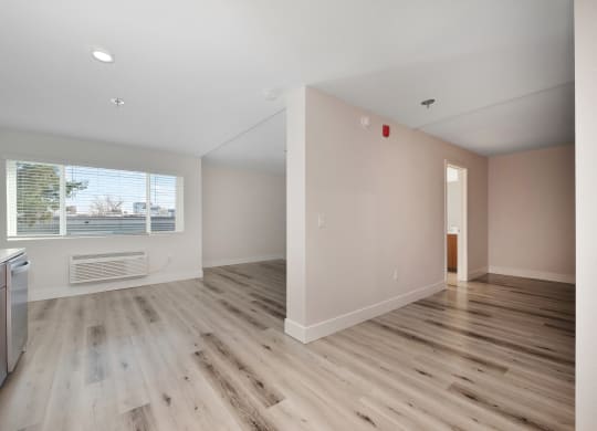 an empty kitchen and living room with wood flooring and a window  at Track 281 Apartments, Sacramento, CA, 95811