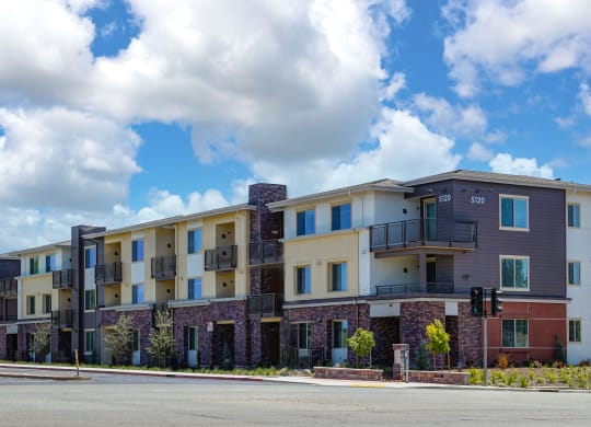a picture of an apartment building with a cloudy sky in the background