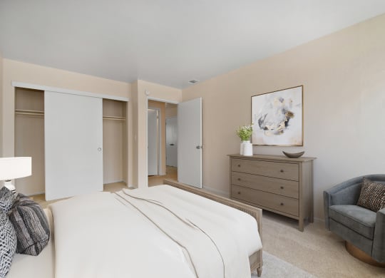 a bedroom with a white bed and a chair
