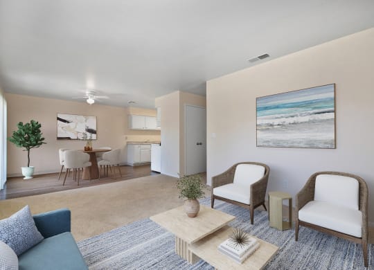 a living room with a couch and two chairs and a dining room