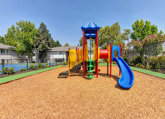 Outdoor Play Structure On-site with bark around it. at The Renaissance Apartments, Citrus Heights, CA
