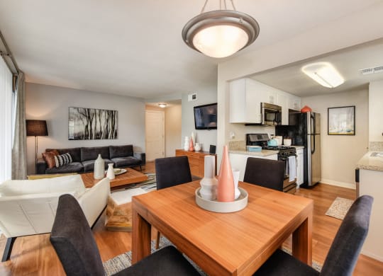 Living Room with Wooden Table, Black Chairs, View of Kitchen with Fridge/Freezer, Oven, Stove, Wood Inspired Floor at Addison Ranch Apartments, California, 94954