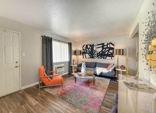Living Room with Hardwood Inspired Floors, Orange Chairs and Window  at Olympus Park Apartments, Roseville, CA, 95661