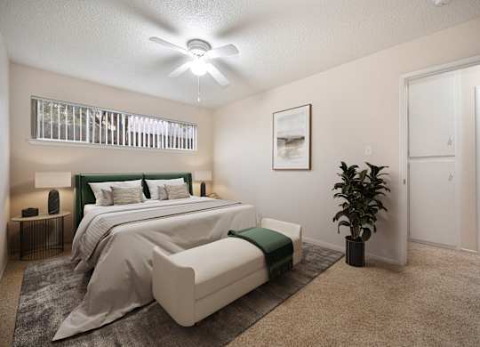 A bedroom with a large bed and a ceiling fan.