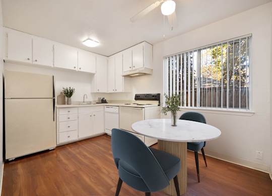 A kitchen with a table and chairs.