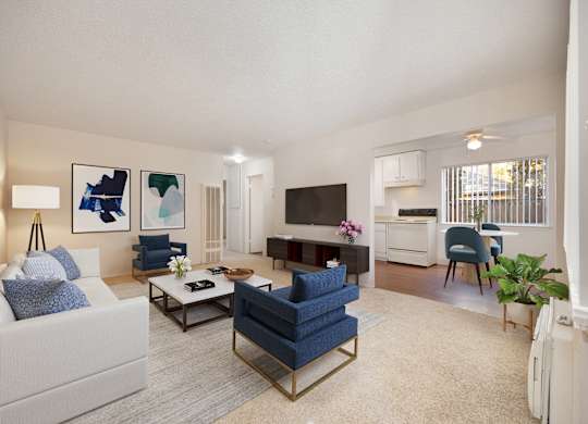 A living room with a white couch, a blue chair, and a television.