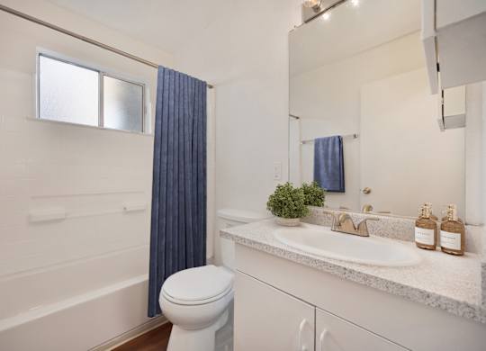 A white bathroom with a white toilet and a white sink.