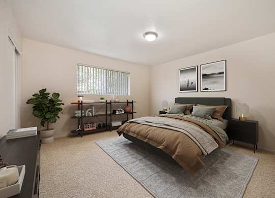 A bedroom with a bed, nightstand, and a plant.