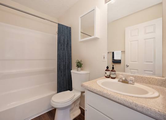 A bathroom with a white toilet, sink, and bathtub.