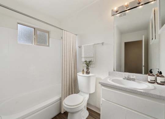 A white bathroom with a toilet, sink, and bathtub.