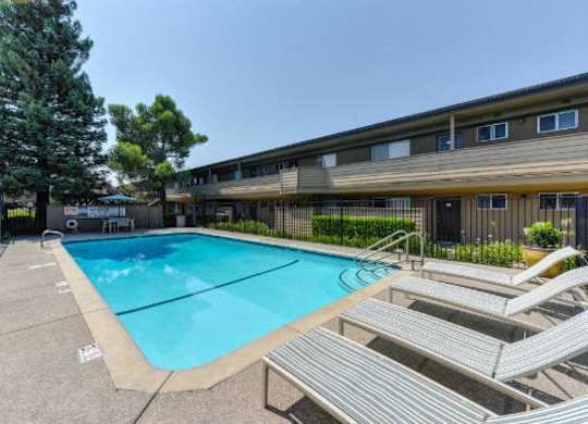 Outdoor Swimming Pool and Lounge Area with Lounge Chairs, Apartment Exteriors and Trees  at Olympus Park Apartments, Roseville, 95661