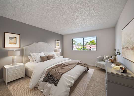 A well-lit bedroom with a large bed and a window showing a view of the outdoors.