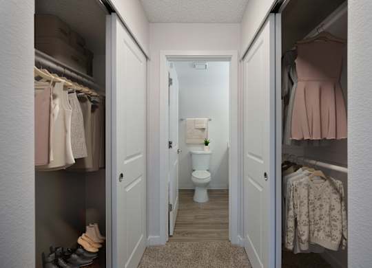 A small bathroom with a toilet and a plant in the middle.