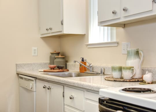 a kitchen with white cabinets and white appliances at Renaissance Park Apartments, Davis, CA, 95618
