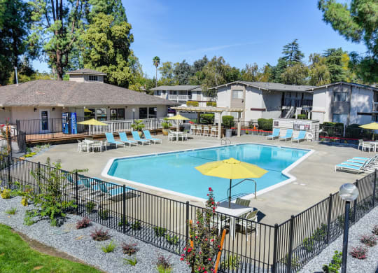 Swimming pool area which is fenced and multiple lounging options around the pool deck. at Renaissance Park Apartments, California
