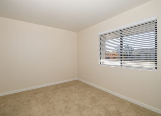The One Bedroom Home bedroom with a window and a carpeted floor at Rocklin Manor  Apartments, Rocklin