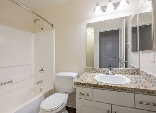 A white toilet sits in a bathroom next to a sink.
