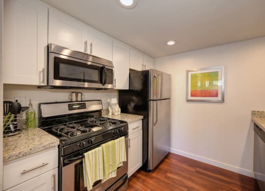 Kitchen Stove with Refrigerator, Hardwood Inspired Floor  and Microwave at Rocklin Manor  Apartments, California, 95677