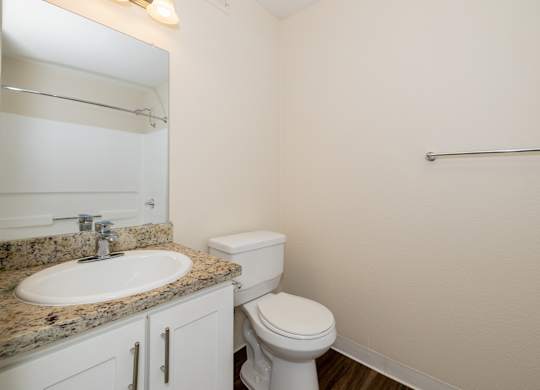 A white toilet sits next to a sink in a bathroom.