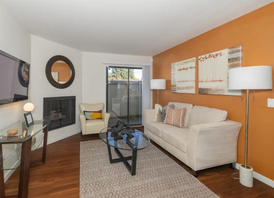 a living room with a couch and a glass coffee table and a fireplace at Rocklin Manor  Apartments, Rocklin  , California