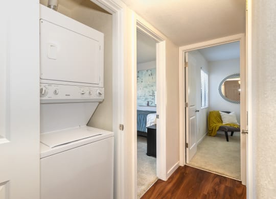 a laundry room with a washer and dryer and a door to a bedroom at Rocklin Manor  Apartments, California, 95677