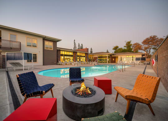 Poolside Fireplace Seating with colorful chairs at Sierra Gateway Apartments