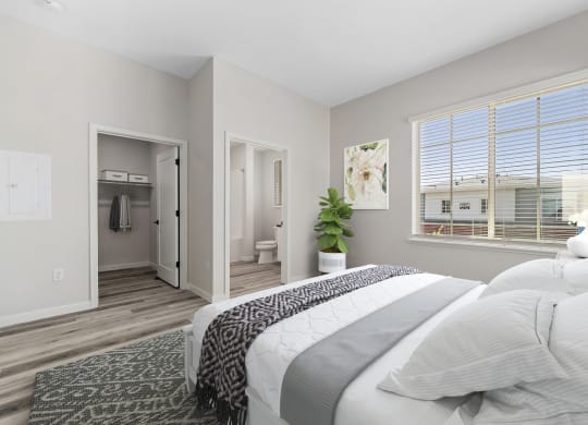 a bedroom with a large window and a large bed with extended closet