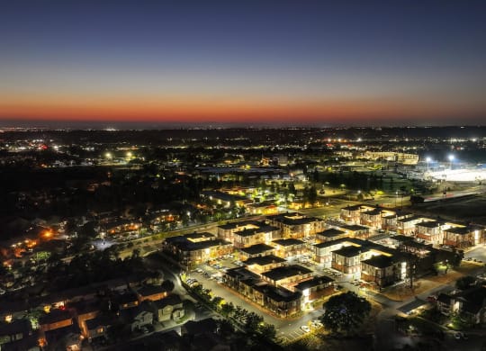 an aerial view of Sierra Gateway Apartments at night with Sierra College in the distance with the stadium lights lit up.