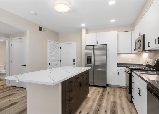a renovated kitchen with white cabinets and stainless steel appliances