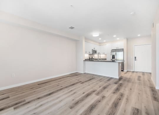 a living room with white walls and hardwood inspired floors