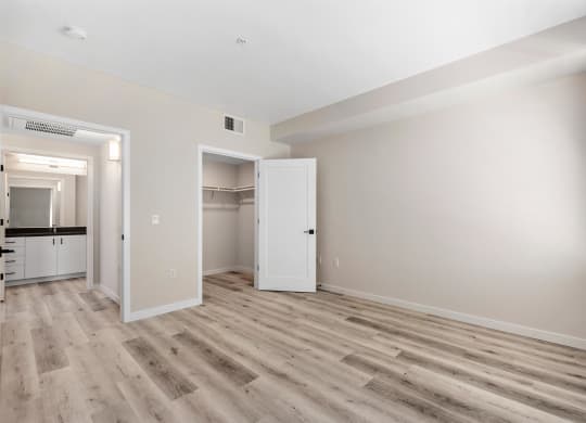 an empty living room with white walls and wood flooring