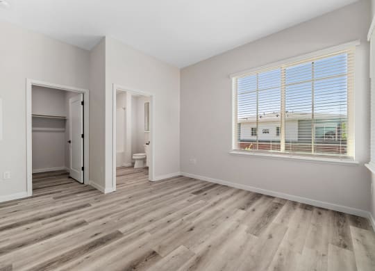 an empty room with a window and a door to a bathroom