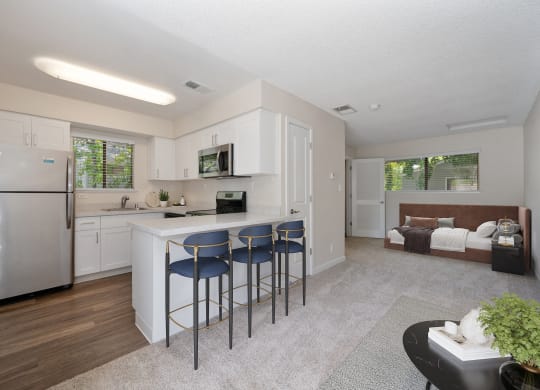 a kitchen with a bar with three stools at Silverstone Apartments, Davis, CA, 95618
