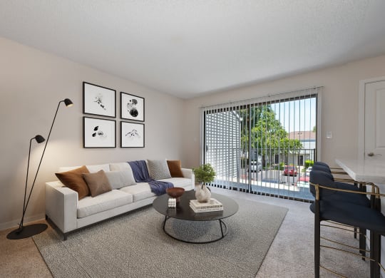 an open living room with a couch and a coffee table and a balcony at Silverstone Apartments, Davis, California