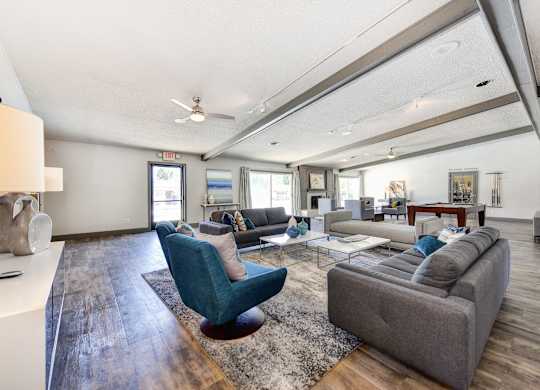 Clubhouse Sitting Area with Hardwood Inspired Floor, Gray Sofa, Rug and Ceiling Fan/Light at The Renaissance Apartments, Citrus Heights