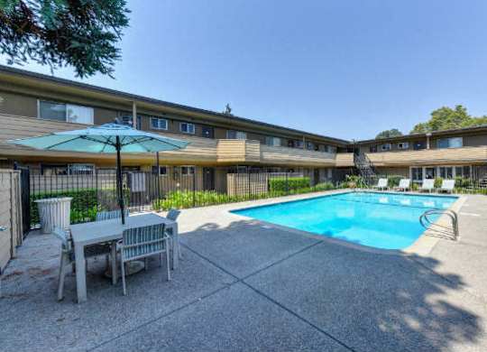 Swimming Pool and Lounge Area, Table and Sun Umbrella  at Olympus Park Apartments, Roseville, CA