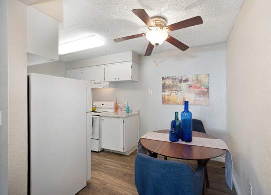 a kitchen and dining area with a table and a ceiling fan