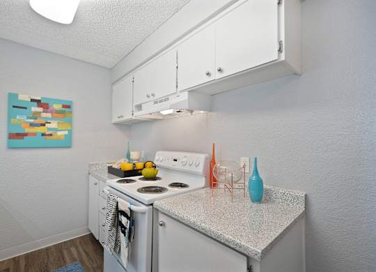 a kitchen with white appliances and a granite counter top