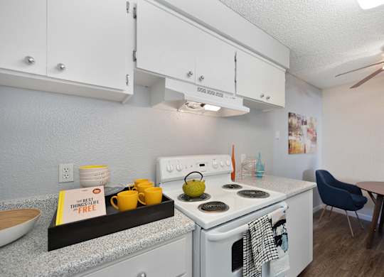 Kitchen with Stove with light colored Walls, Stove, Hardwood Inspired Floor and White Cabinets at The Renaissance Apartments, Citrus Heights