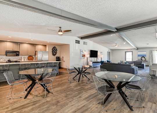 Community clubhouse with Hardwood Inspired Floors, and numerous seating areas and tables.at The Renaissance Apartments, Citrus Heights