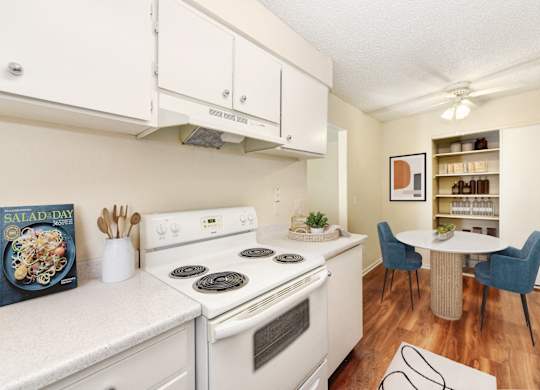 A white kitchen with a stove, oven, and a book titled