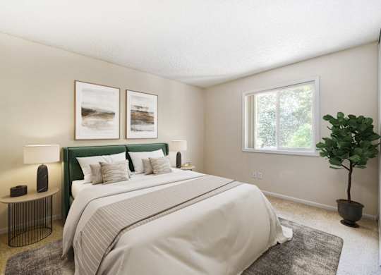 A bedroom with a large bed and a green headboard.