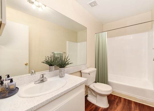 A white toilet sits next to a white sink in a bathroom.