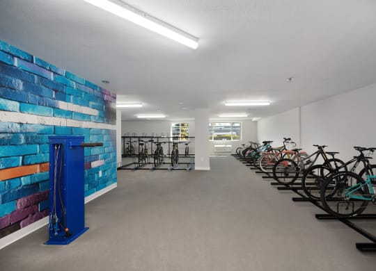 the club room has bikes parked in front of a colorful brick wall with a mosaic