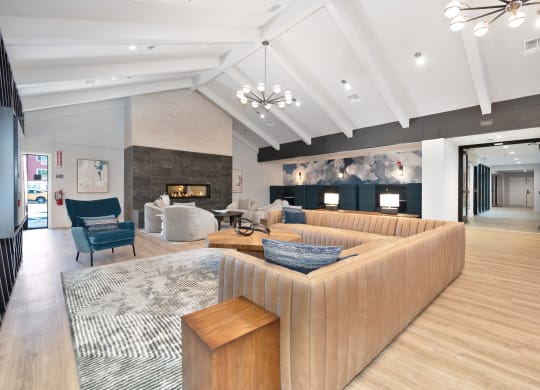 The Community clubhouse with vaulted beamed ceilings, multiple seating areas, and a fireplace  at Track 281 Apartments, Sacramento, CA, 95811