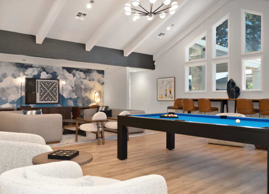 a living room with a pool table and couches  at Track 281 Apartments, Sacramento, CA