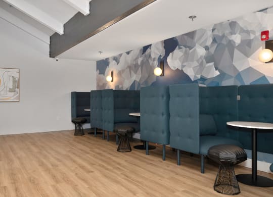 a room with blue couches and stools and a wall with a geometric design  at Track 281 Apartments, California