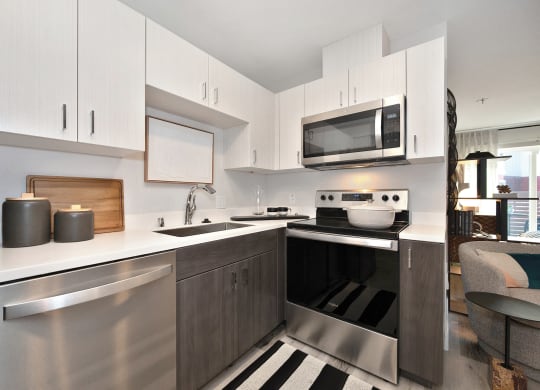 a modern kitchen with stainless steel appliances and white cabinets  at Track 281 Apartments, Sacramento, CA, 95811