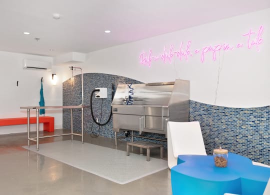 a kitchen with a grill and a table and a pink neon sign  at Track 281 Apartments, Sacramento, CA